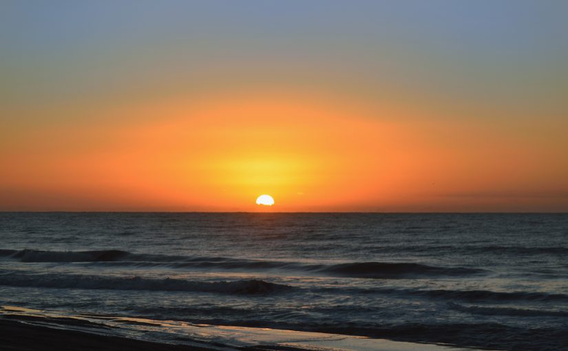 Dawn along the Atlantic Ocean shoreline in North Myrtle Beach, SC with a beautiful orange cast from the rising sun