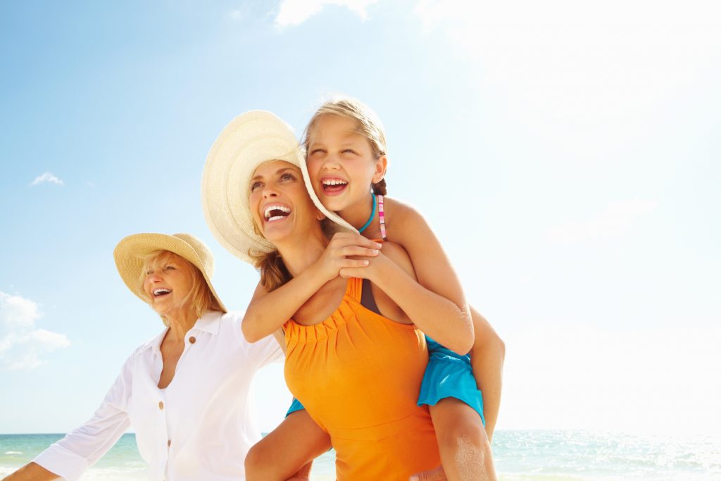 Three generations together - Happy grandmother, granddaughter and daughter enjoying at a beach